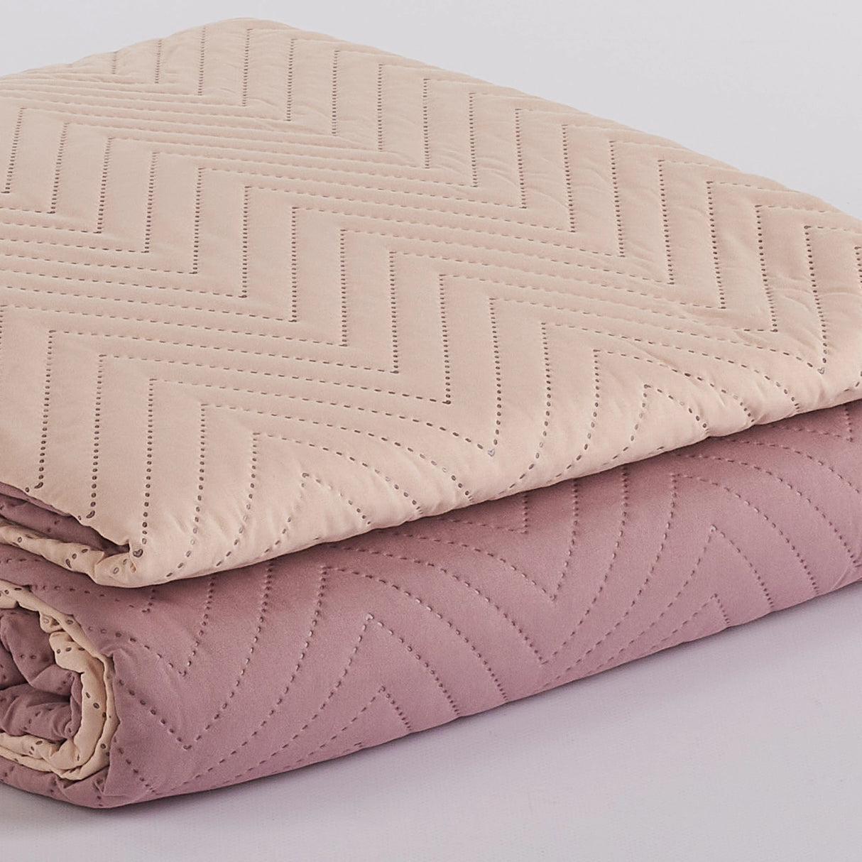 Dettaglio trapuntatura ultrasonica moderna su copriletto reversibile Rosa Antico.