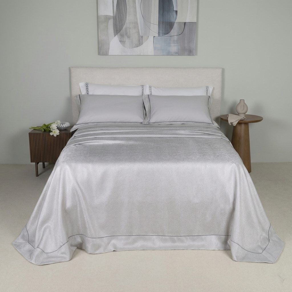 Copriletto matrimoniale elegante Battaglia modello Laura grigio perla steso sul letto.