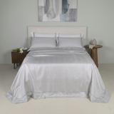 Copriletto matrimoniale elegante Battaglia modello Laura grigio perla steso sul letto.