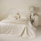 Copriletto matrimoniale jacquard Keran Battaglia variante colore panna aperto sul letto.