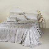 Copriletto matrimoniale jacquard Keran Battaglia variante colore perla steso sul letto.