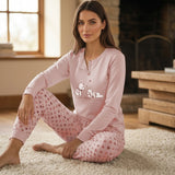 Modella seduta su tappeto indossa il pigiama rosa da donna Karelpiù 1082 in caldo cotone con grafica cagnolini e pantaloni a cuoricini