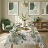 Tavola apparecchiata in stile moderno naturale con la tovaglia Aura verde con stampe di grandi foglie e fiori verdi.